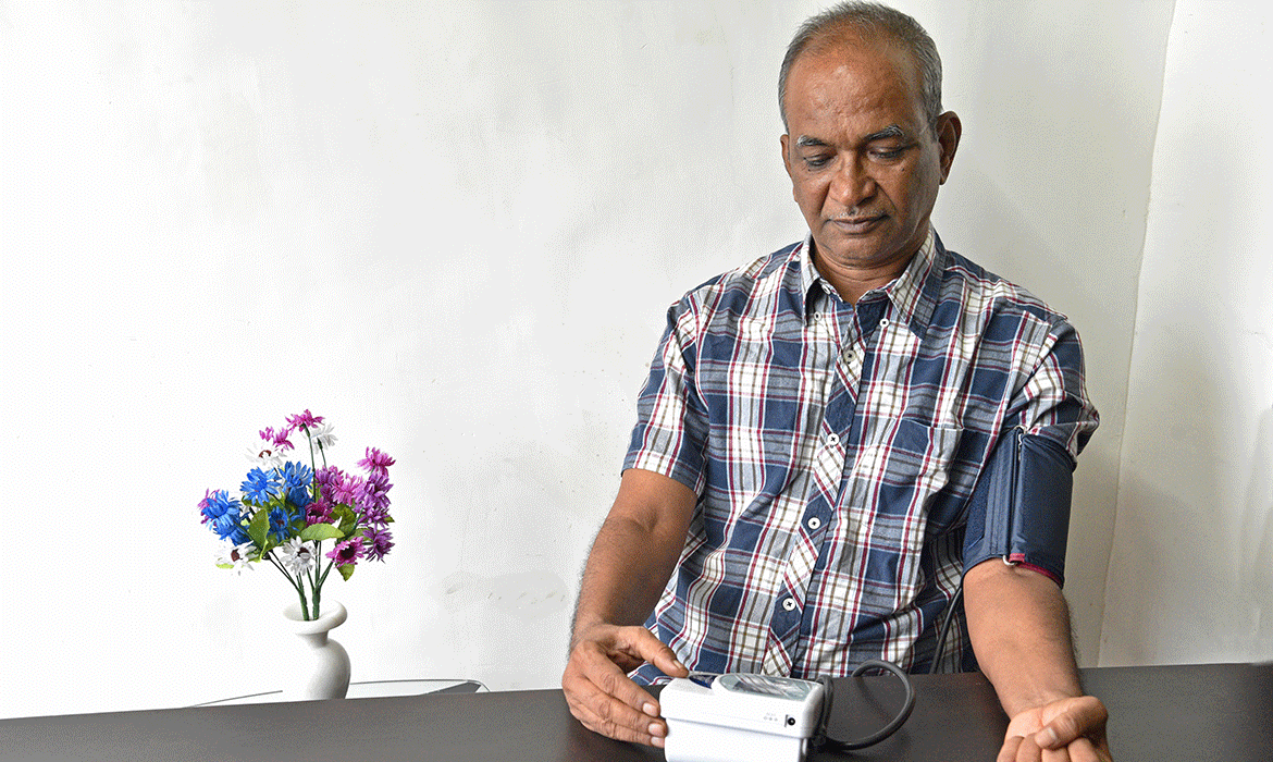 Man at home blood pressure cuff