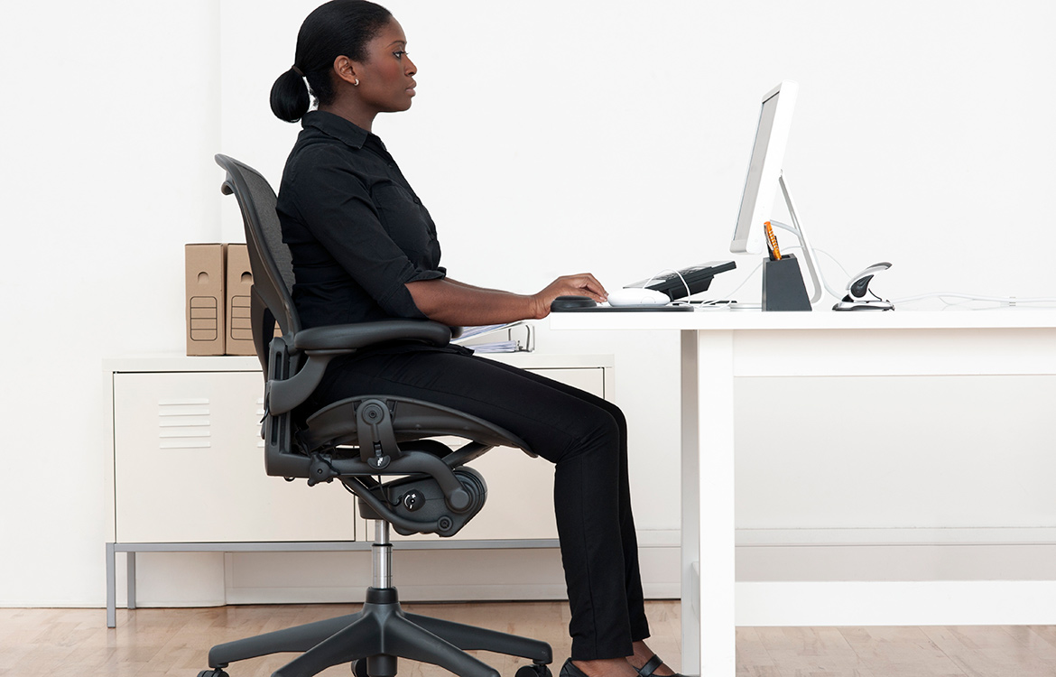 woman showing proper desk ergonomics