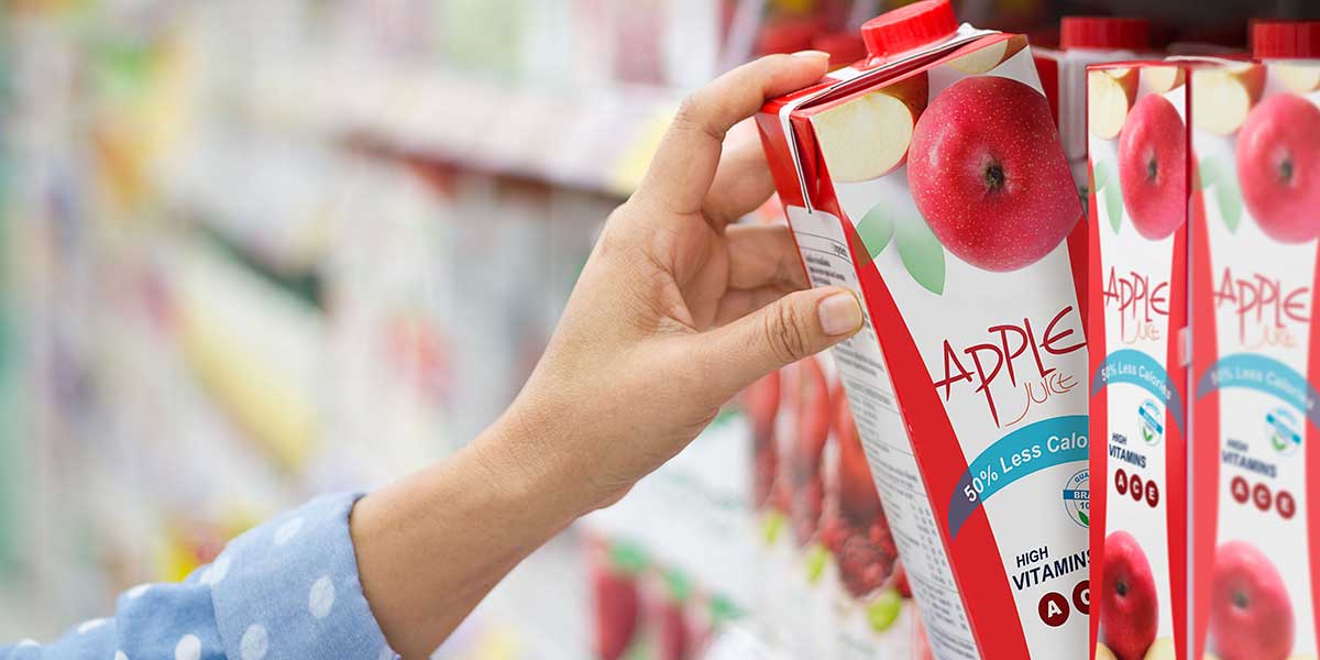 Woman pulling apple juice off the grocery shelf