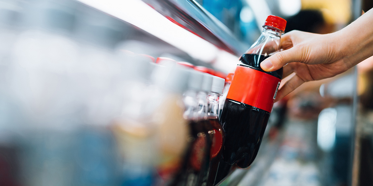 Someone grabbing a soda from a convenience store