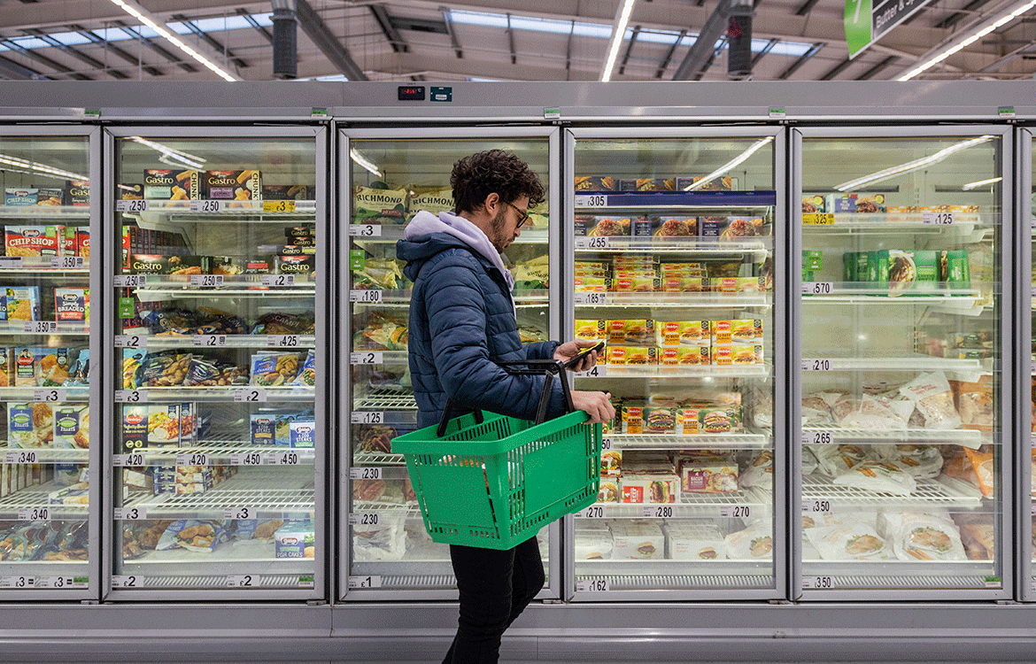 Man in jacket grocery shopping in frozen food aisle