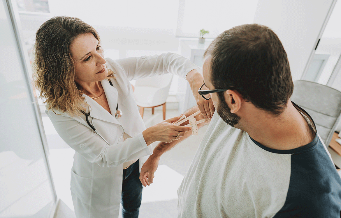 Doctor taking skin fold measurement of patient