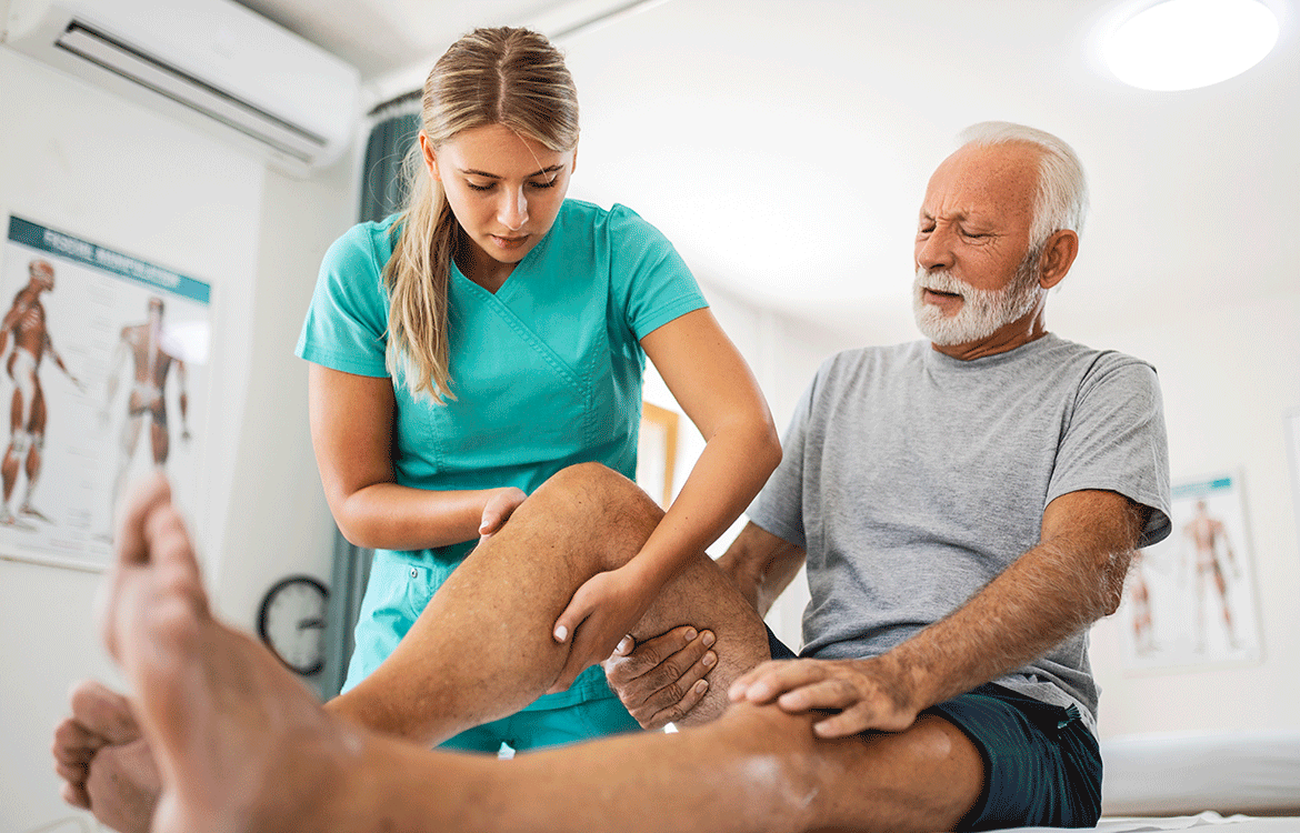 Physical therapist stretching older man