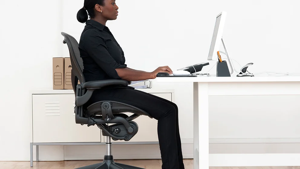 woman showing proper desk ergonomics