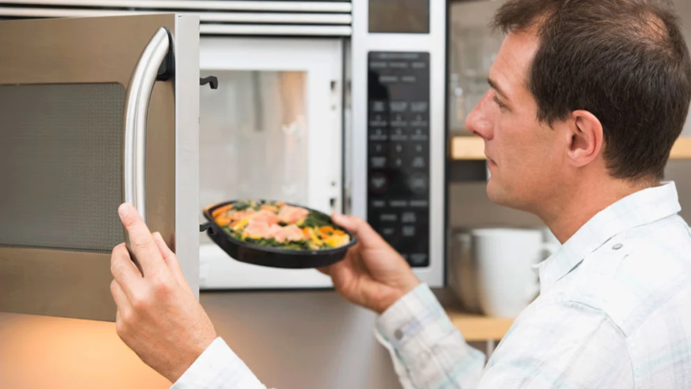 Man microwaving processed meal