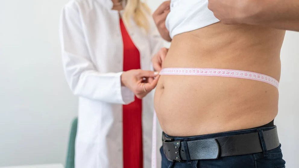 physician taking waist to hip ratio of patient