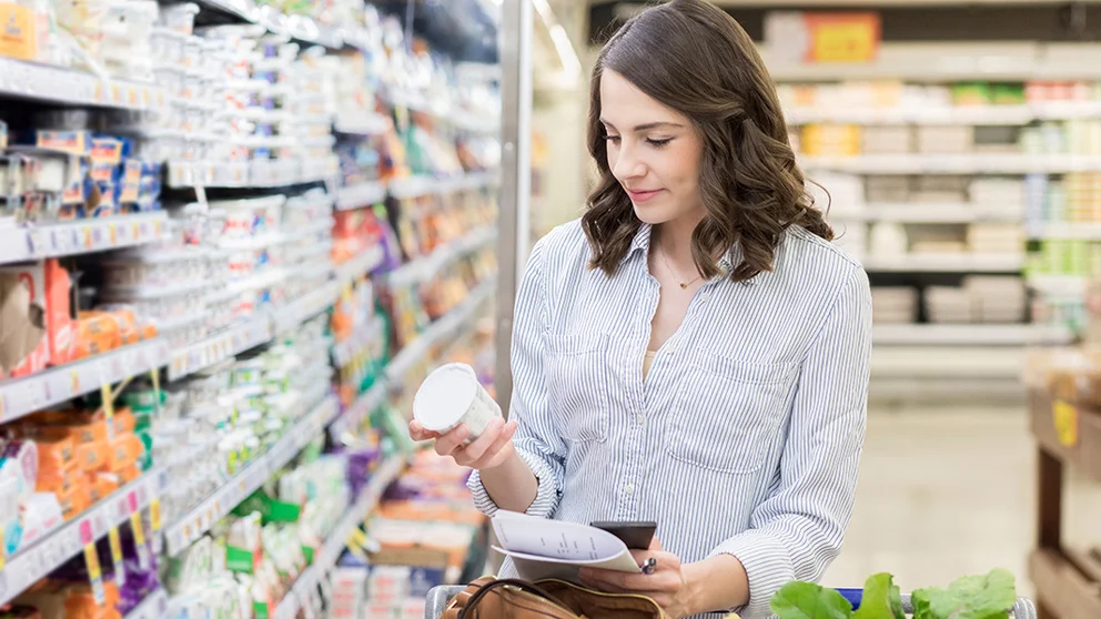 Woman shopping for yogurt with live probiotic cultures