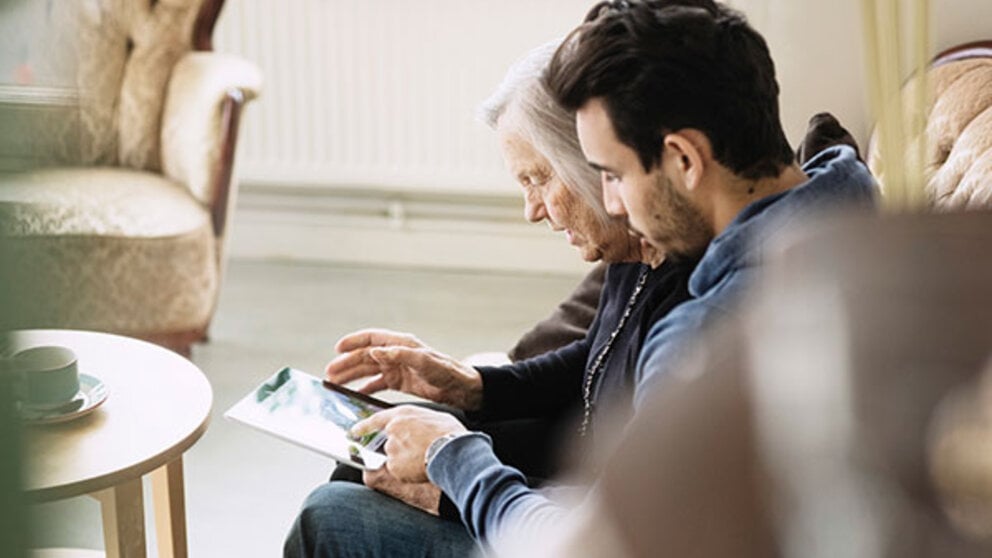 A man talks to his elderly mother who has dementia
