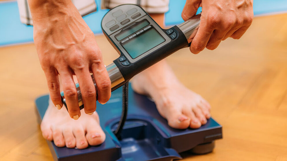 Woman using body composition scale