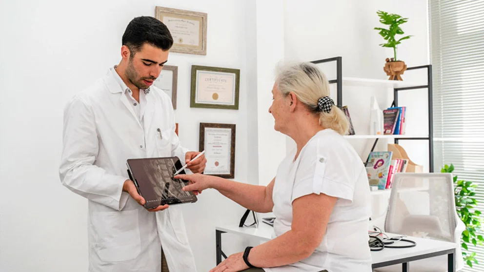 Male physician with female patient explaining spinal scan
