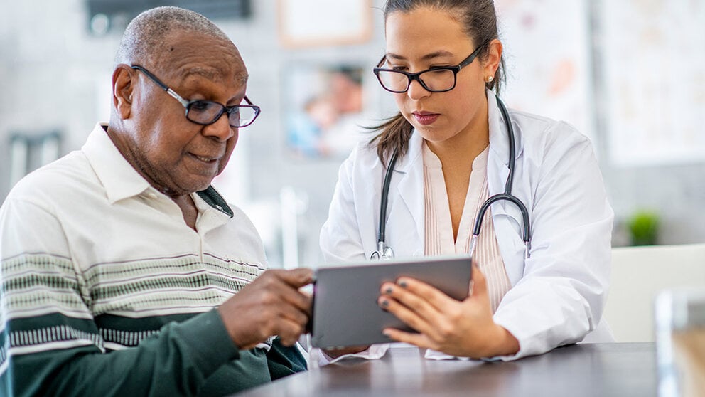 woman doctor helping older male patient