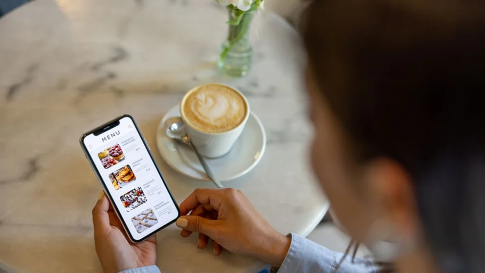 Coffee house patron looking at nutrition facts mobile app