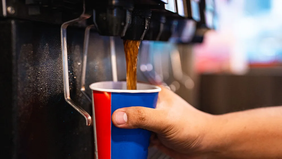 Diet cola poured from fountain into red and blue cup