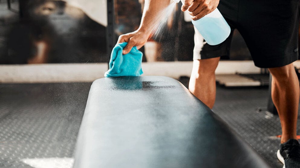 Wiping down bench in fitness center