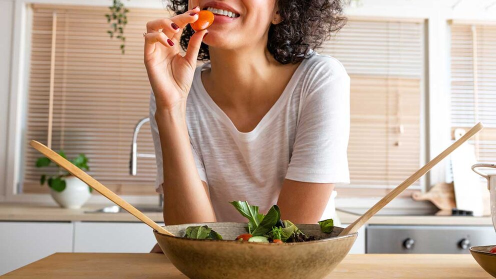 A woman eating vegetables.