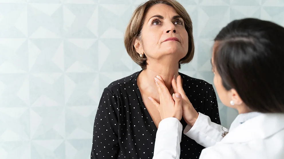 Doctor checking patient's thyroid