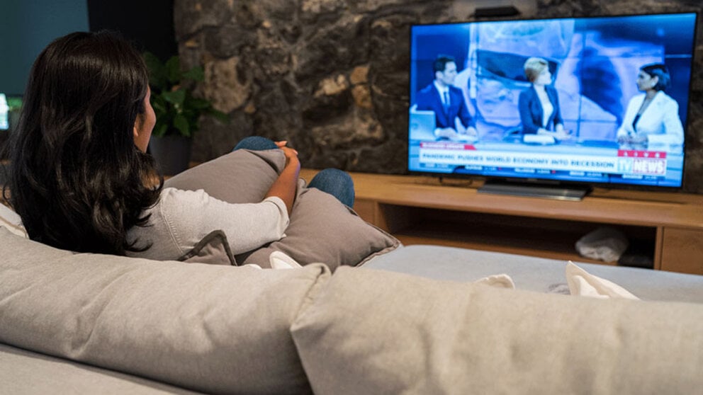 Women on a couch watching the news