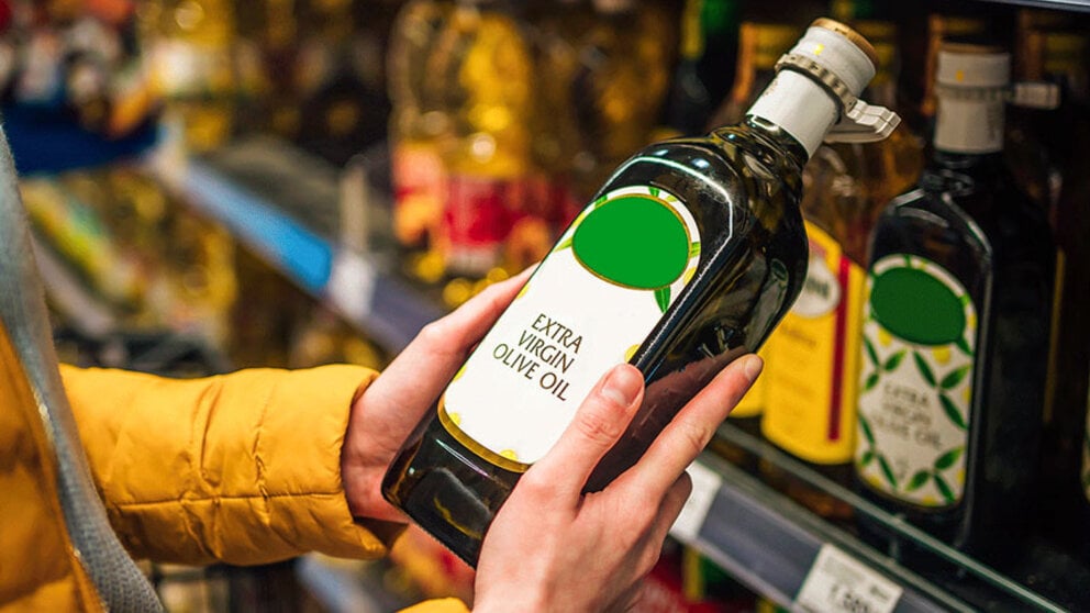 Woman looking at bottle of extra virgin olive oil at supermarket