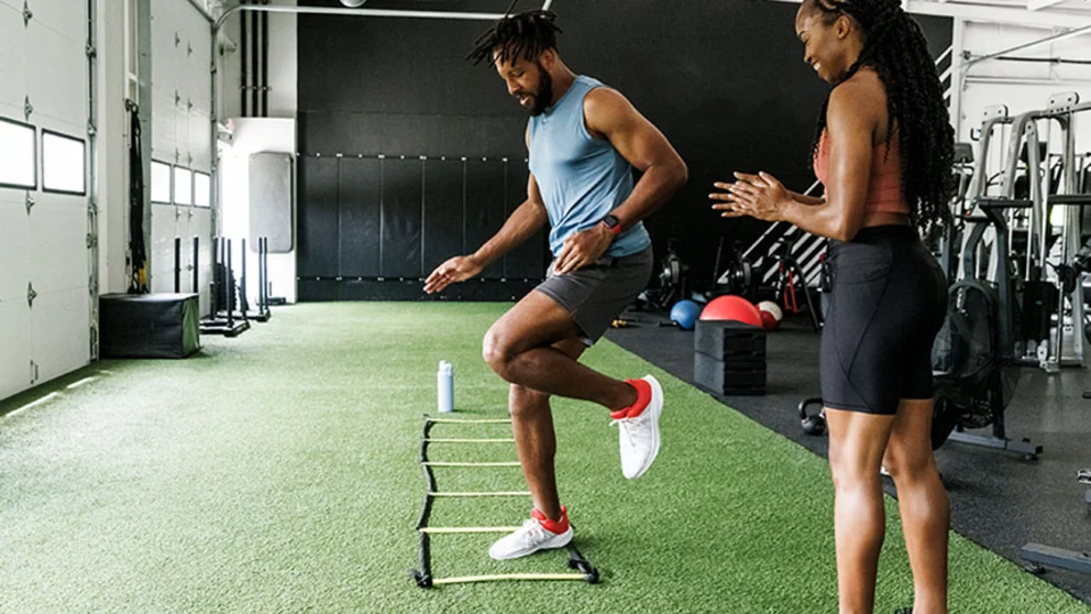 A man practices ladder drills for agility.