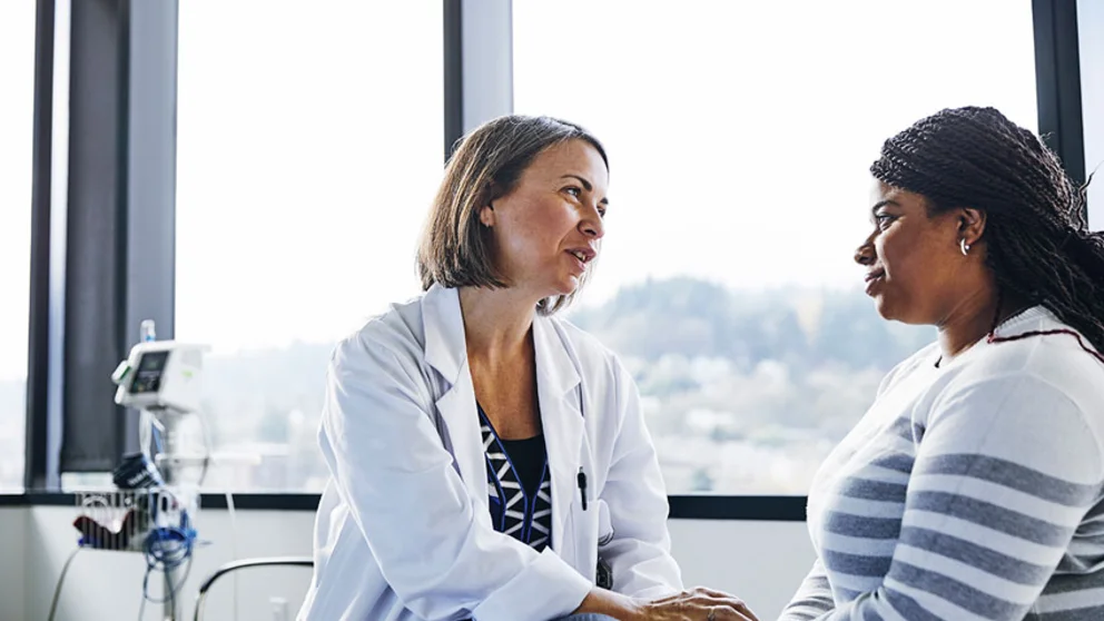 A woman speaking with a female doctor