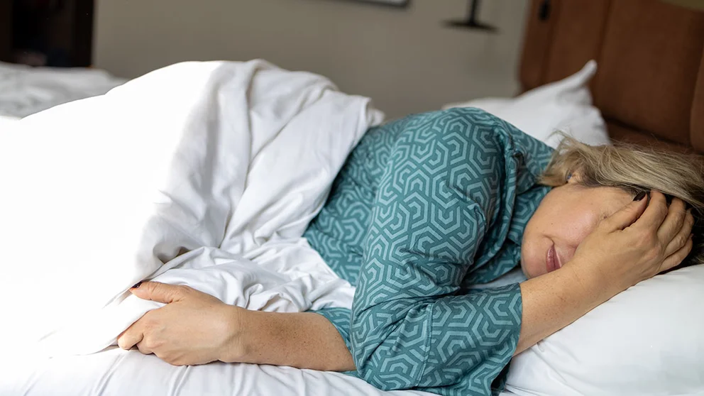 Woman in bed with migraine