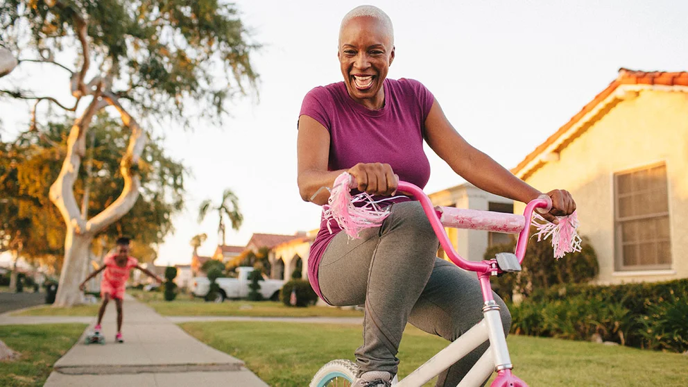 Grandmother riding tricycle with granddaughter.