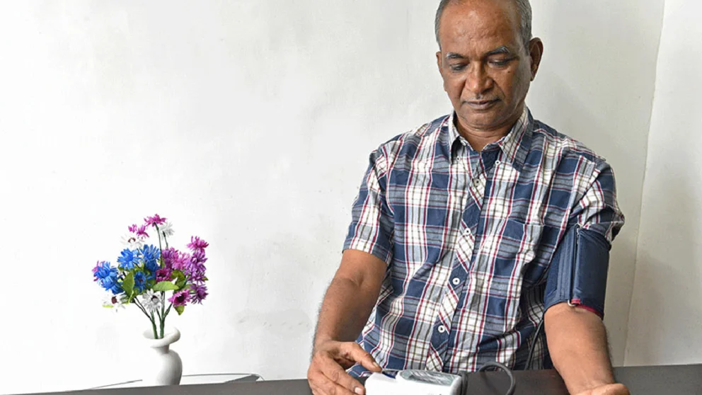 Man using a home blood pressure machine