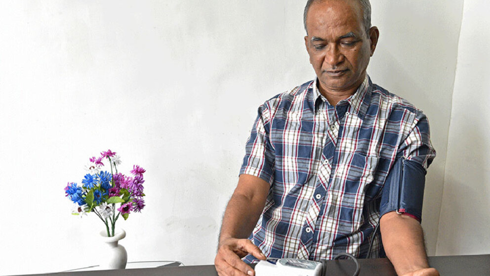 Man using a home blood pressure machine