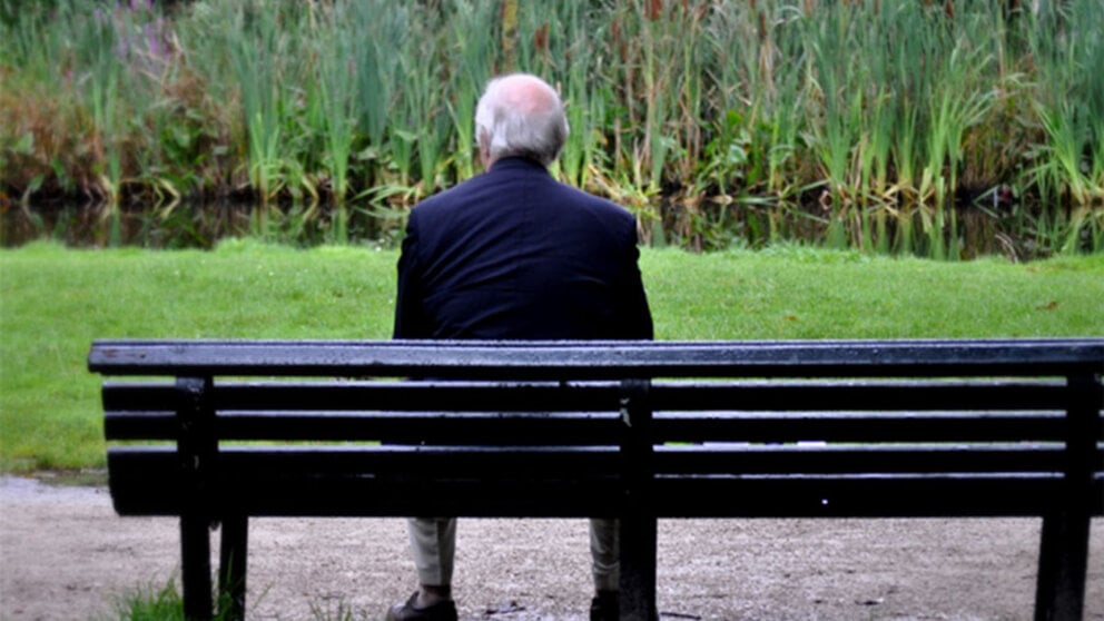 A older man sitting alone on a bench. Loneliness and social isolation can lead to real health issues.