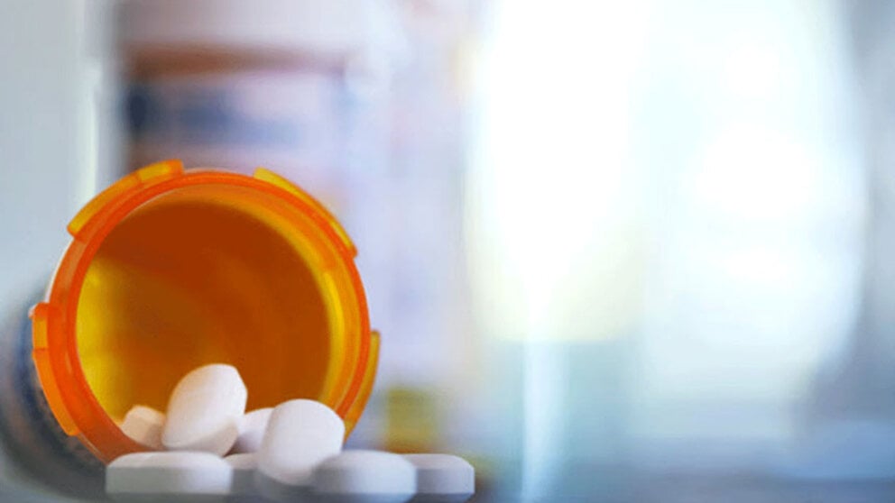 Pills spilling out of a tipped bottle