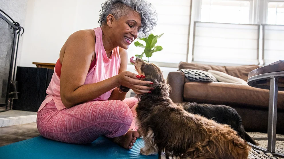 Woman playing on the floor with her dog