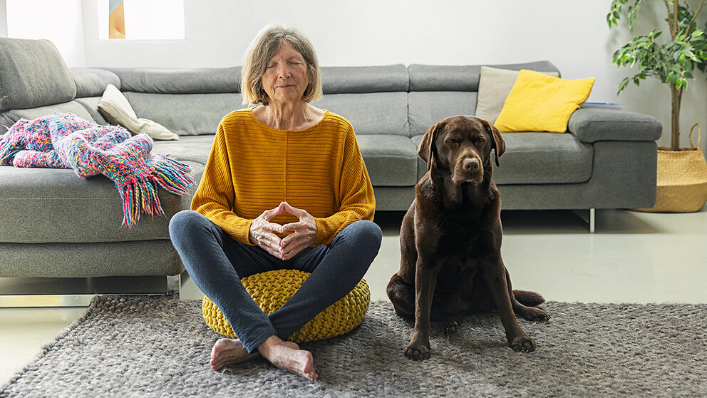 A woman and her dog practicing mindful meditation.
