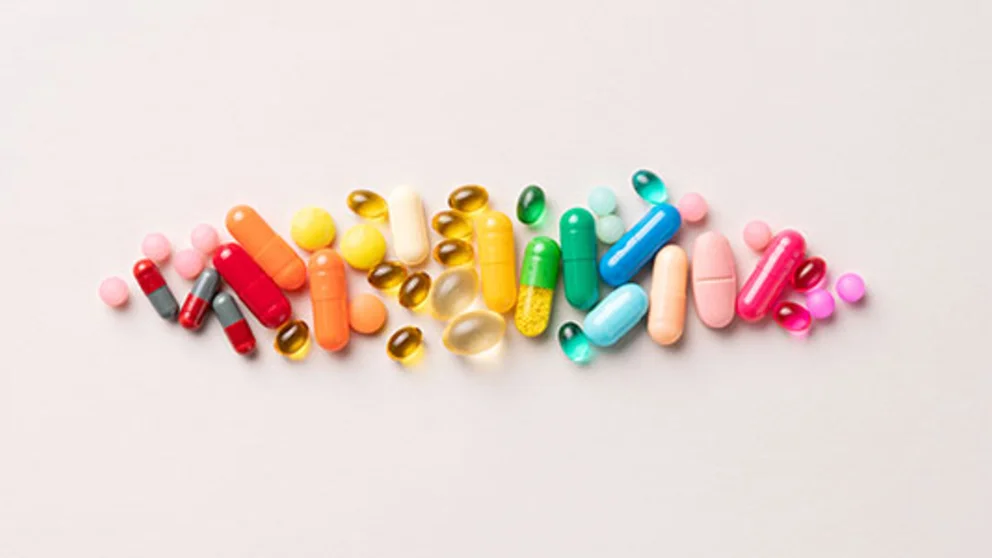 Colorful vitamins and supplements against a light background.