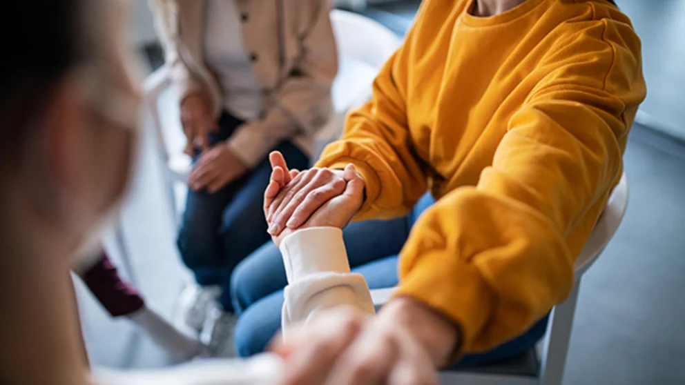 Two people holding hands in a waiting room