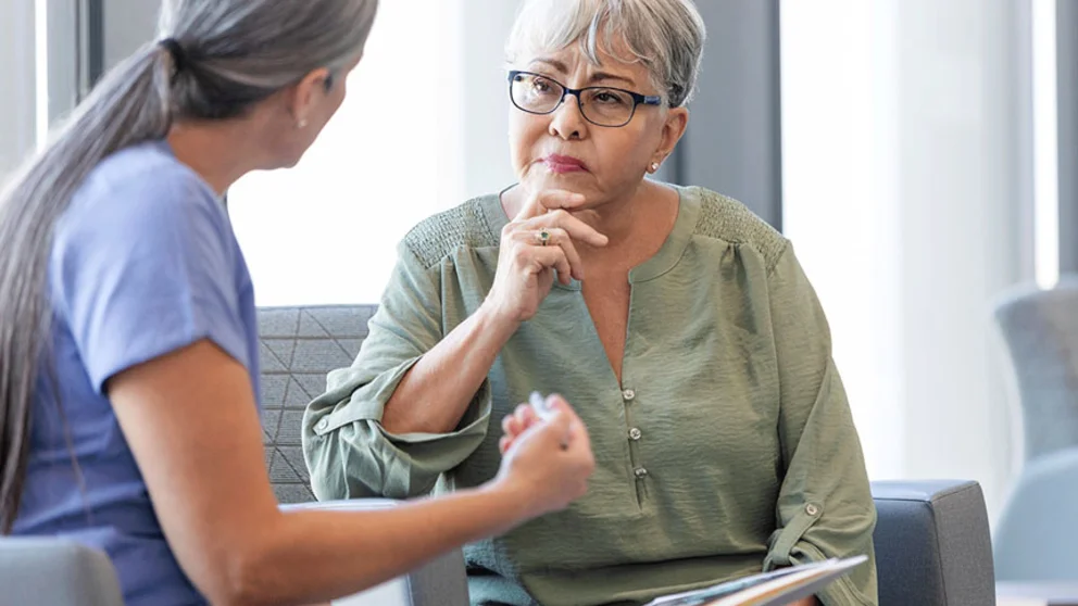 Post-menopausal female patient talking to doctor