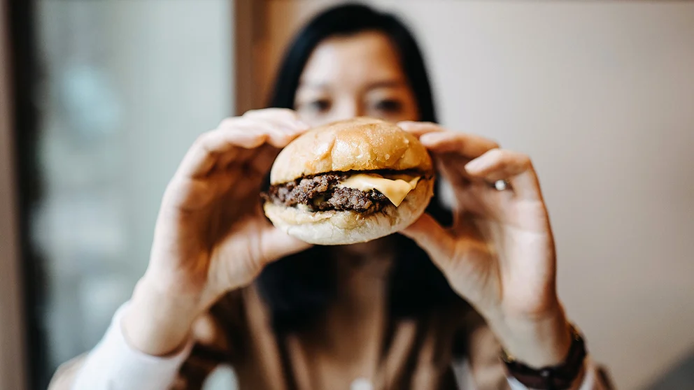 A woman eating a hamburger.