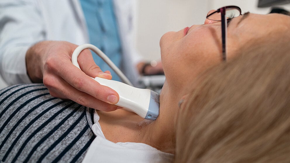 A doctor performs a thyroid ultrasound.