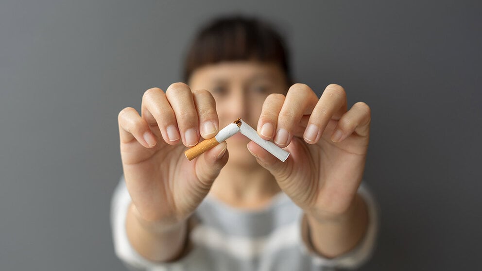 woman breaking cigarette in half
