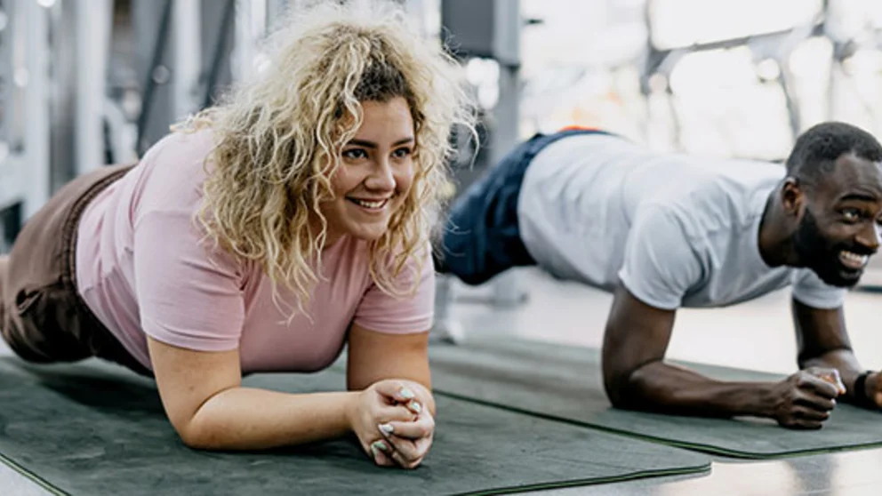 Two people doing planks as resistance training.