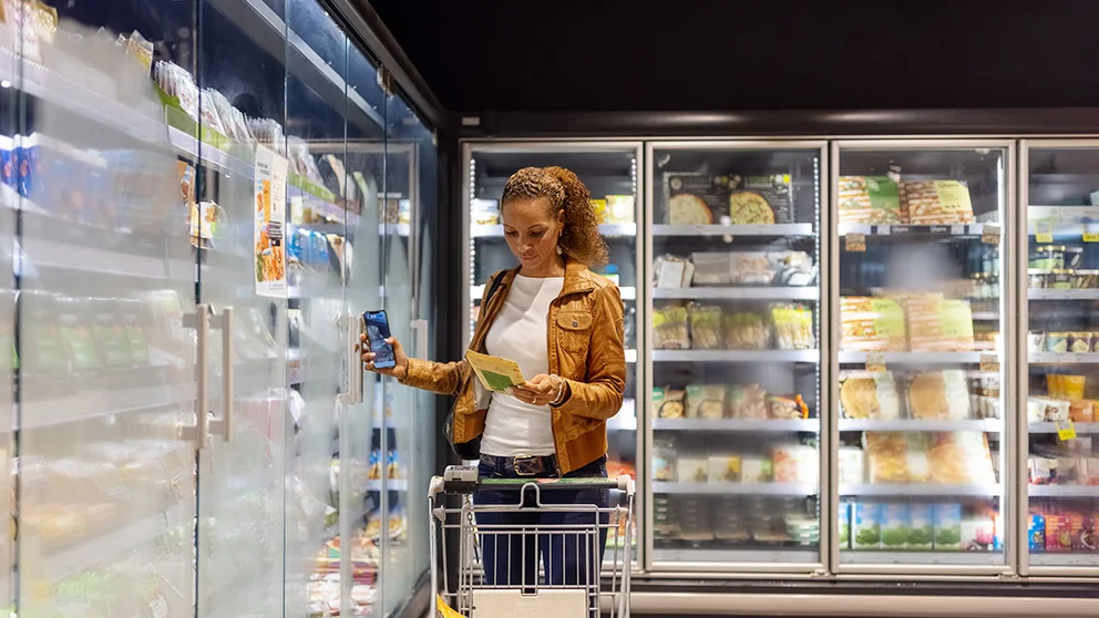 Woman shopping in frozen food section of supermarket