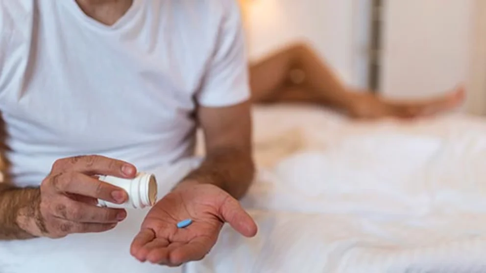 A man prepares to take a pill for impotency