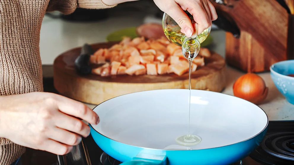 Oil poured into a blue stovetop pan