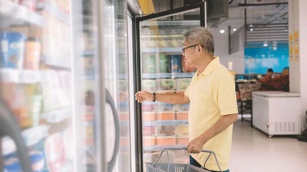 shopper opening fridge door in grocery store