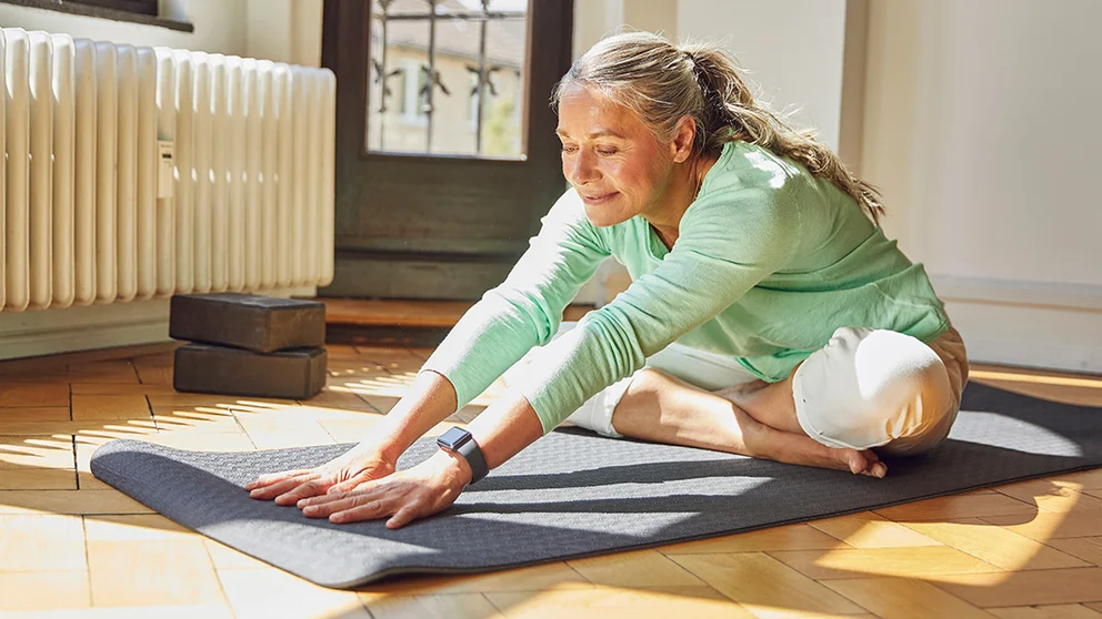 Woman in her early 60s practicing yoga. Exercise is one way to keep practicing prevention as we age.