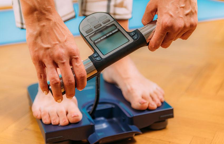 Woman using body composition scale