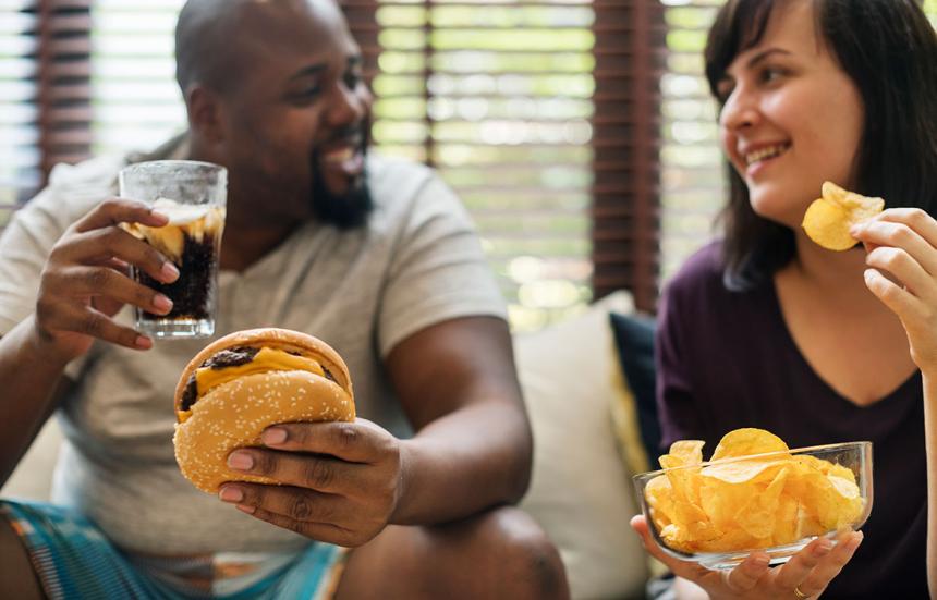 Overweight couple eating unhealthy food