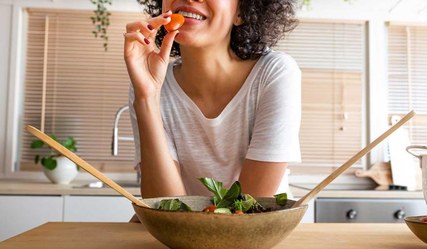 A woman eating vegetables.