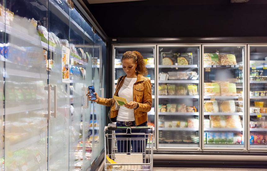 Woman shopping in frozen food section of supermarket