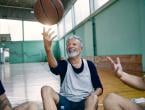 middle aged man tossing basketball into the air
