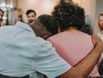 Two people hug during a grief support group meeting.